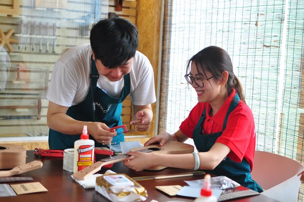 HO正在指导客人制作尤克里里 HO正在指导客人制作尤克里里